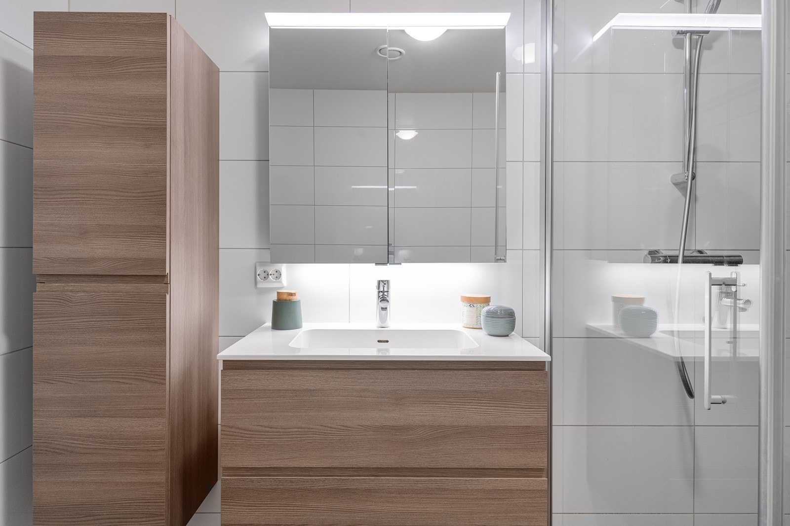 Moderne innredning med nedfelt servant og speilskap gir praktisk oppbevaring. Galleribilde