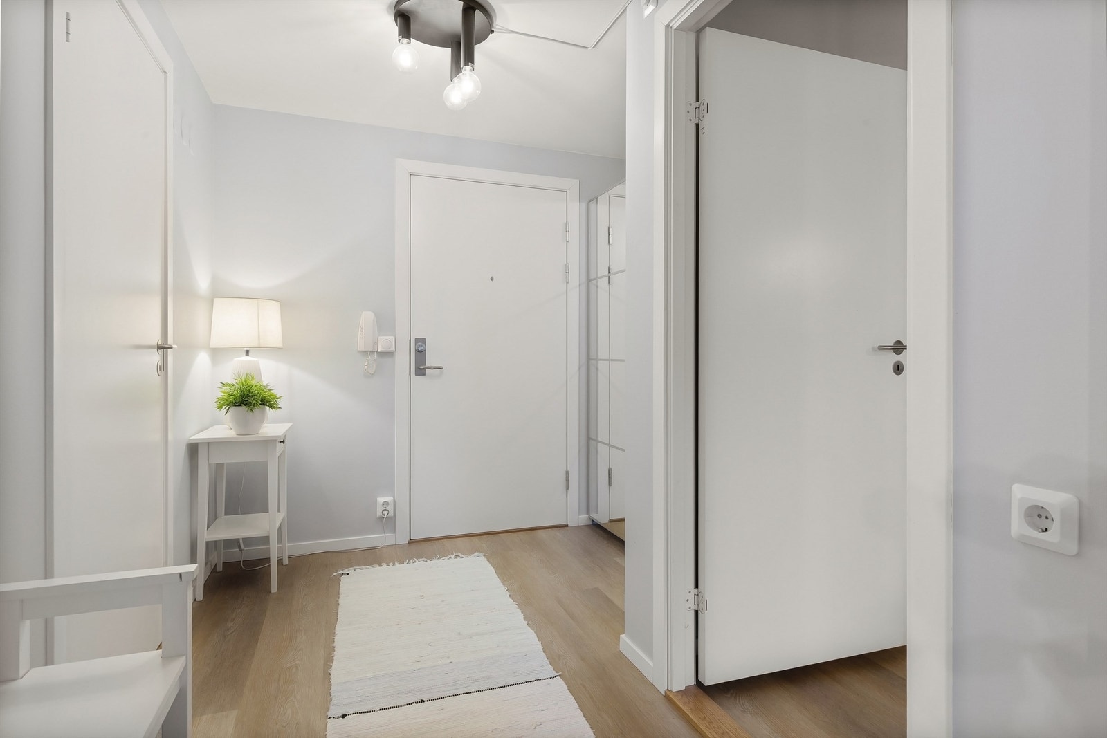 Velkommen inn i en lys entré med parkettgulv og adkomst til leilighetens rom. Galleribilde