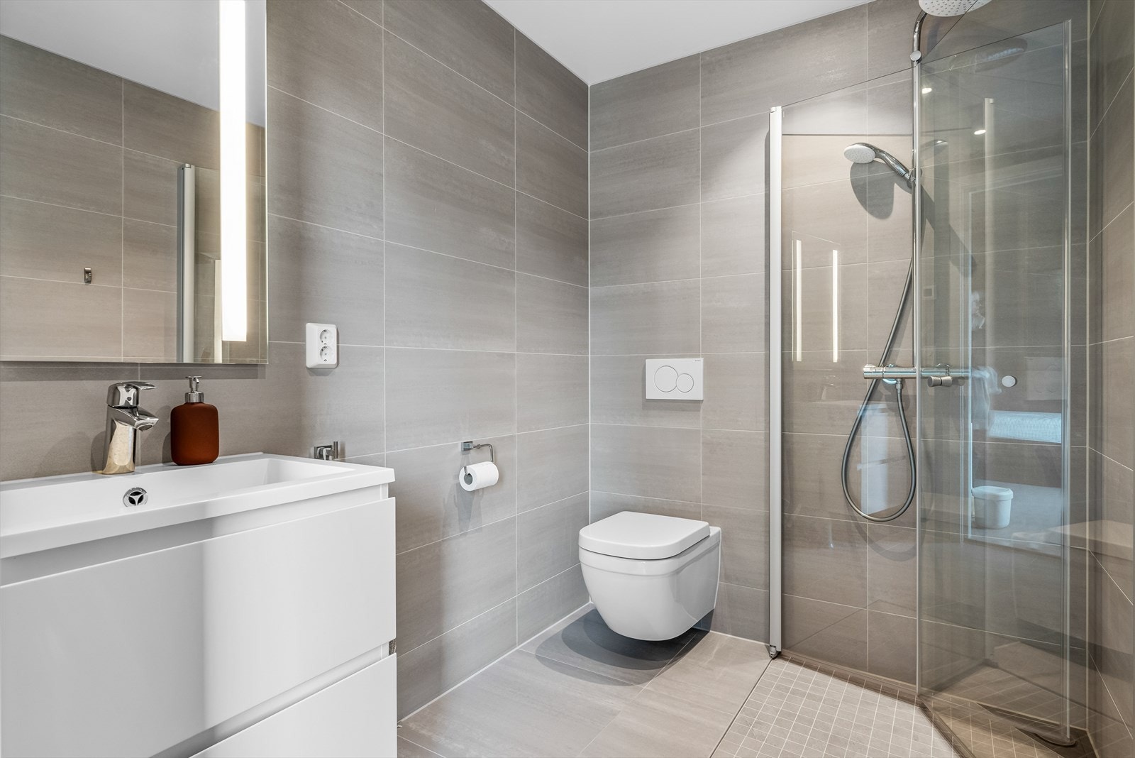 Badene er likt innredet med toalett, regndusj og stilren baderomsinnredning. Galleribilde