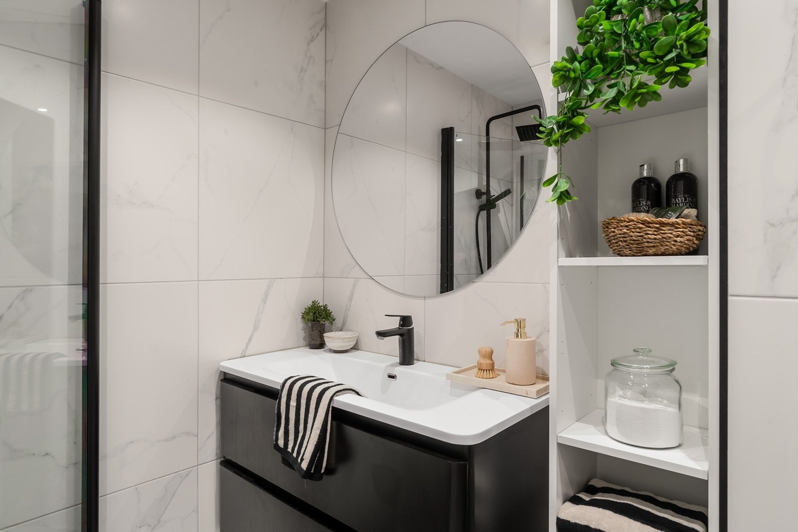 Badet har stilren innredning med heldekkende servant og god oppbevaringsplass. Galleribilde