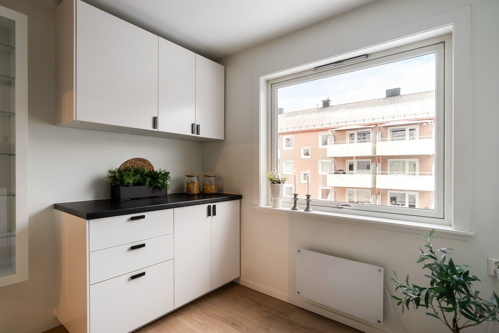 Kjøkkeninnredningen har glatte fronter, integrerte hvitevarer og praktisk benkeplass. Galleribilde