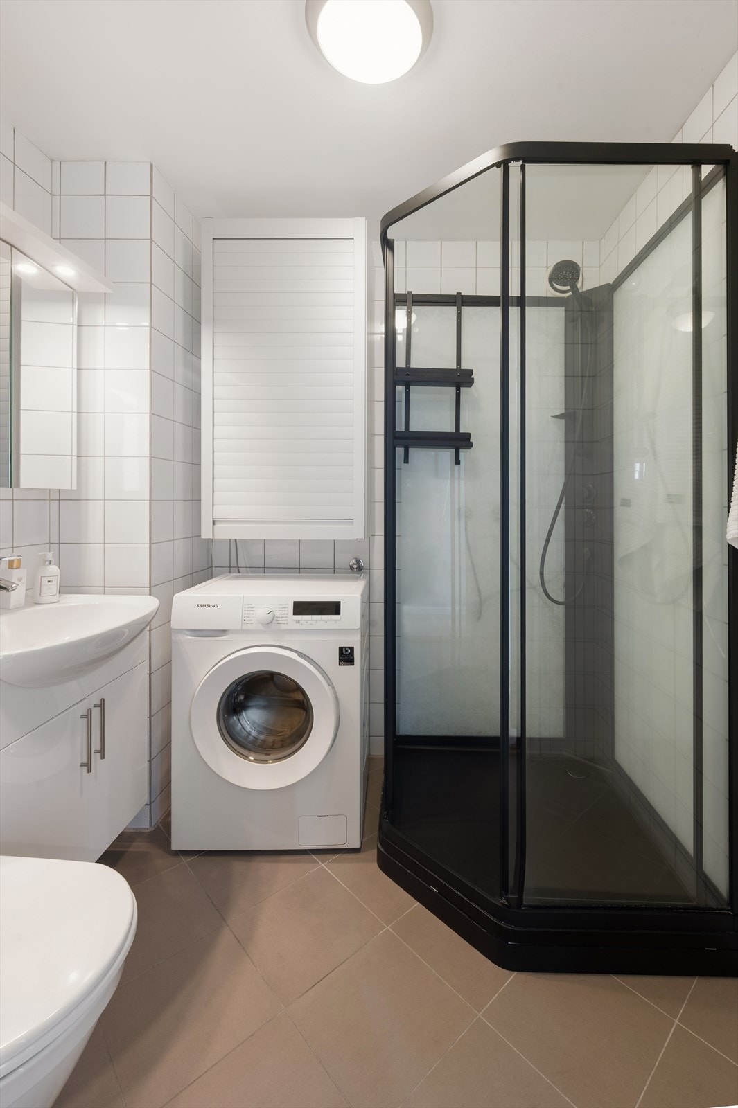Badet er innredet med servant, speilskap, klosett og et praktisk dusjkabinett. Galleribilde