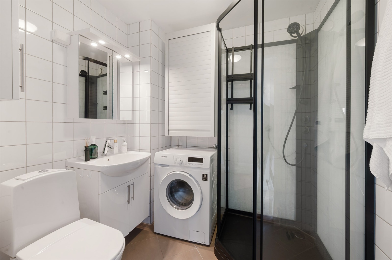 Badet er pent flislagt på gulv og vegger. Elektrisk varme i gulvet sørger for en behagelig start på dagen. Det er opplegg for vaskemaskin. Galleribilde