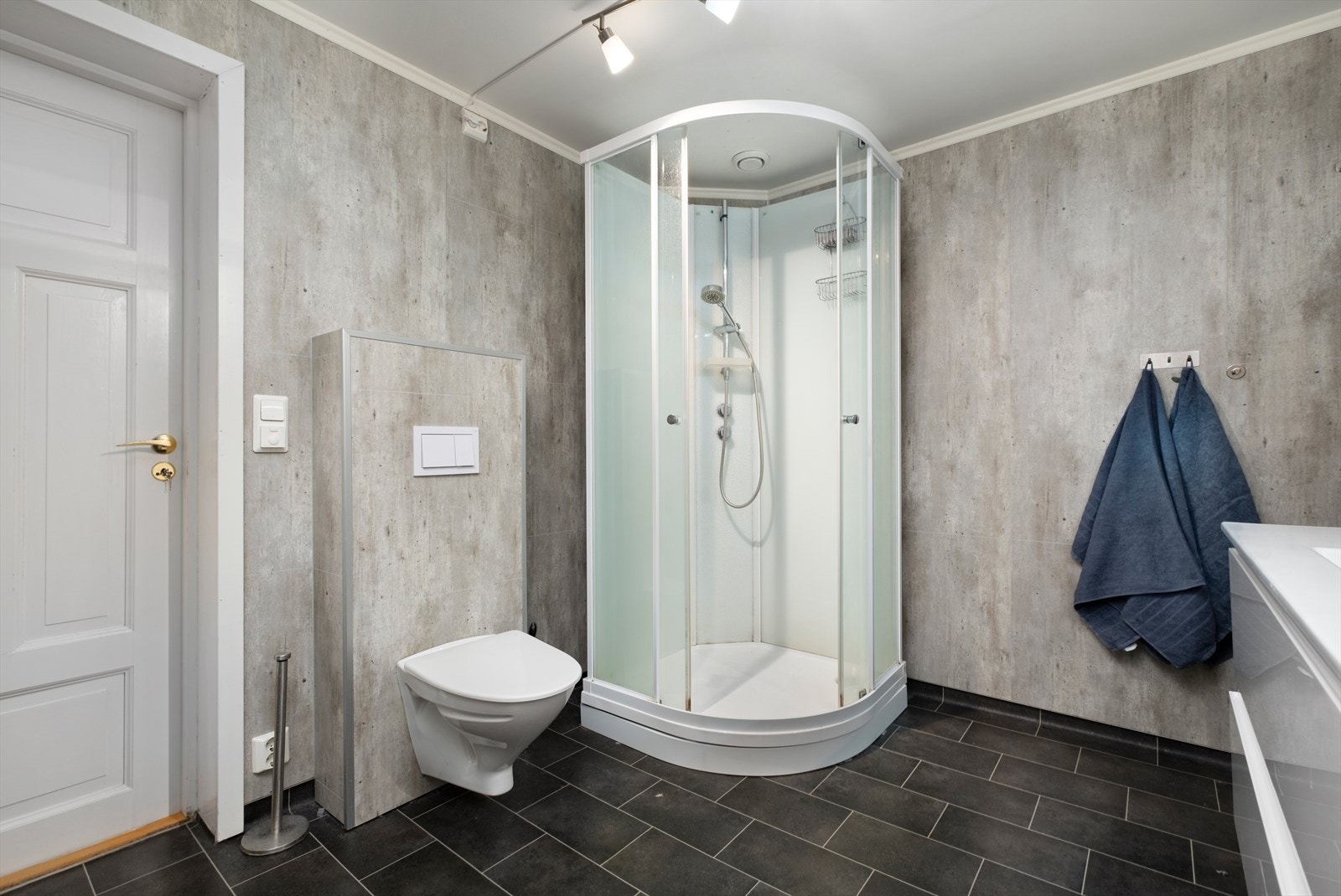 Badet med moderne preg, dusjkabinett, vegghengt toalett og stilrene overflater i gråtoner er oppusset i 2019 Galleribilde