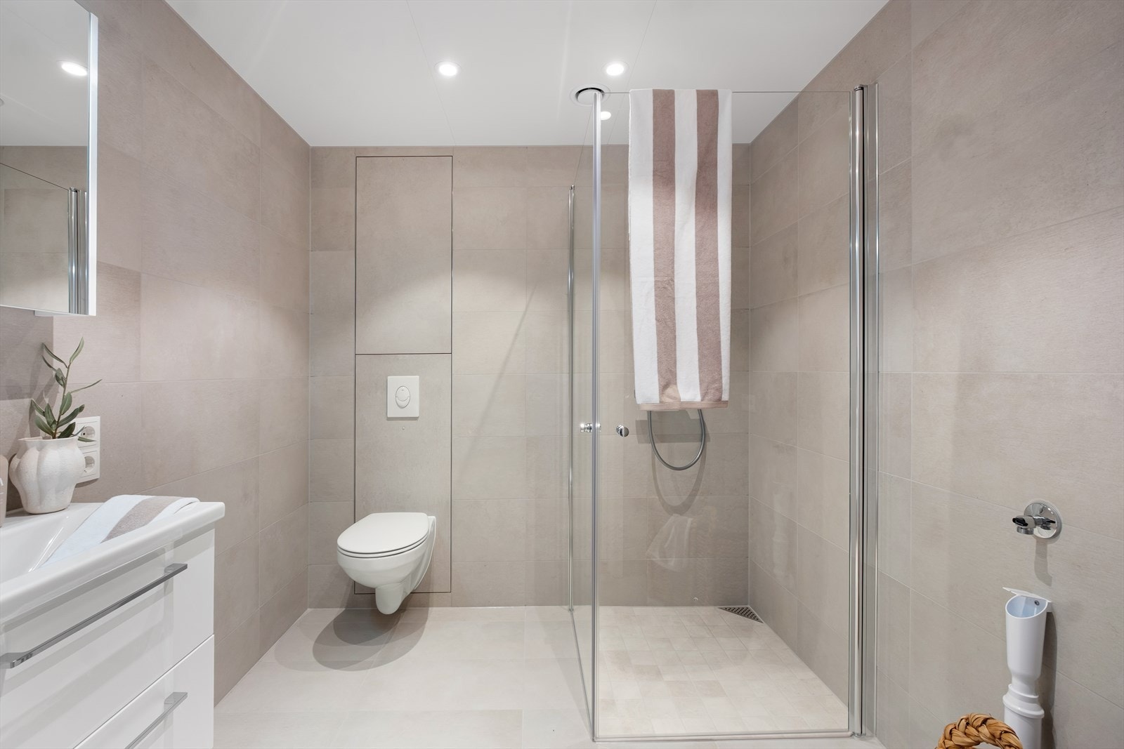 Flislagte overflater og dusjhjørne med glassvegger gir et moderne uttrykk. Galleribilde