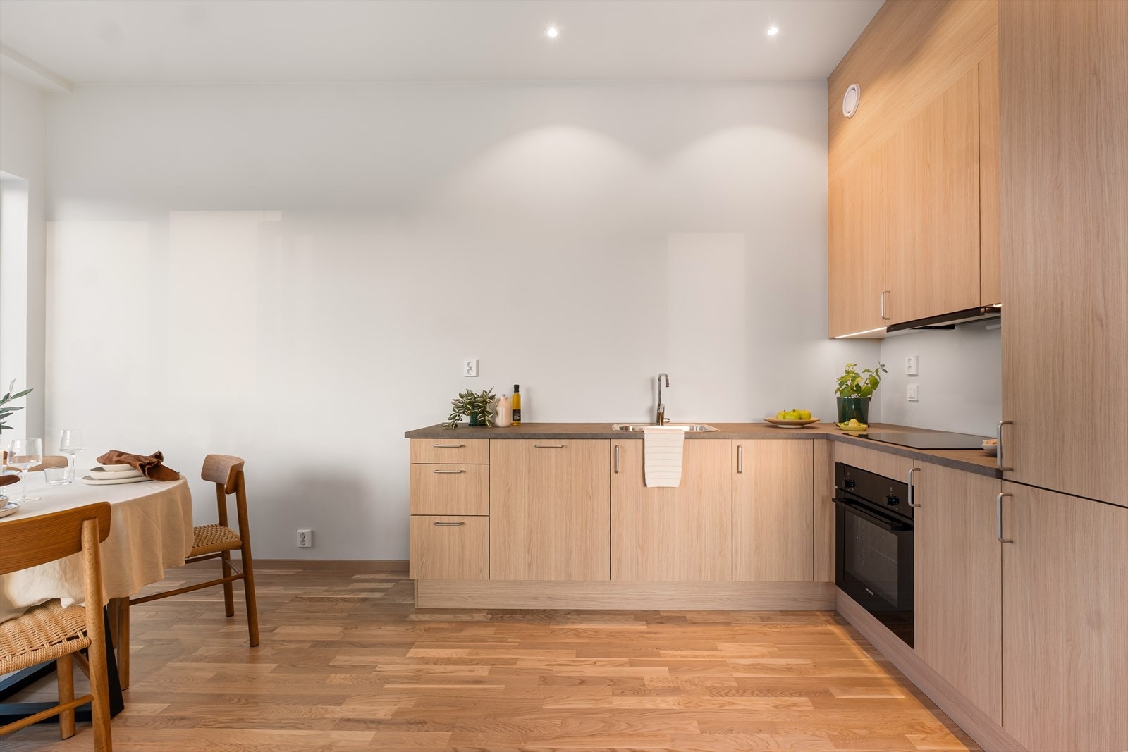 Elegant kjøkken med integrerte hvitevarer og rikelig med skap- og benkeplass. Galleribilde