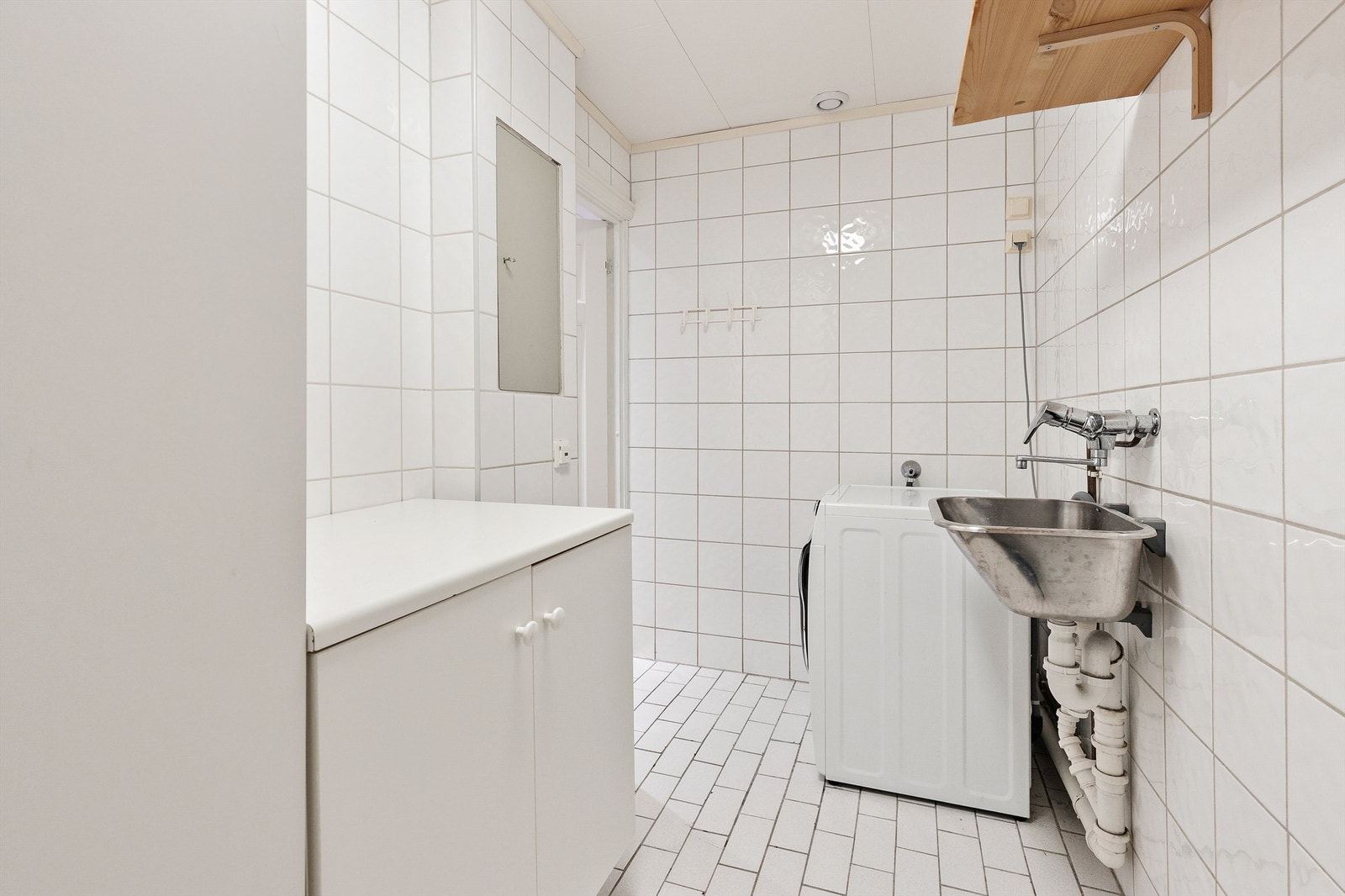 Praktisk, flislagt rom brukt som vaskerom, med gulvvarme og både plass og opplegg for vaskemaskin og tørketrommel. Rommet har ikke sluk, se supplerende tekst i tilstandsrapporten. Rommet er byggemeldt som bod og er ikke godkjent for varig opphold. Galleribilde