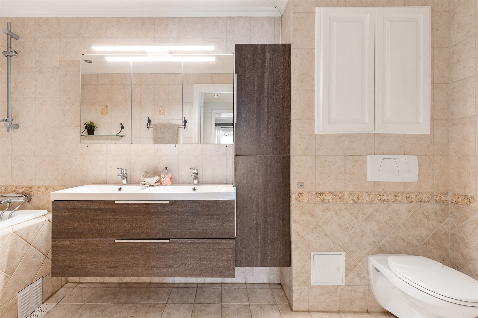 Badet er videre utstyrt med vegghengt klosett, speilskap og vegghengt skap for god oppbevaring. Galleribilde