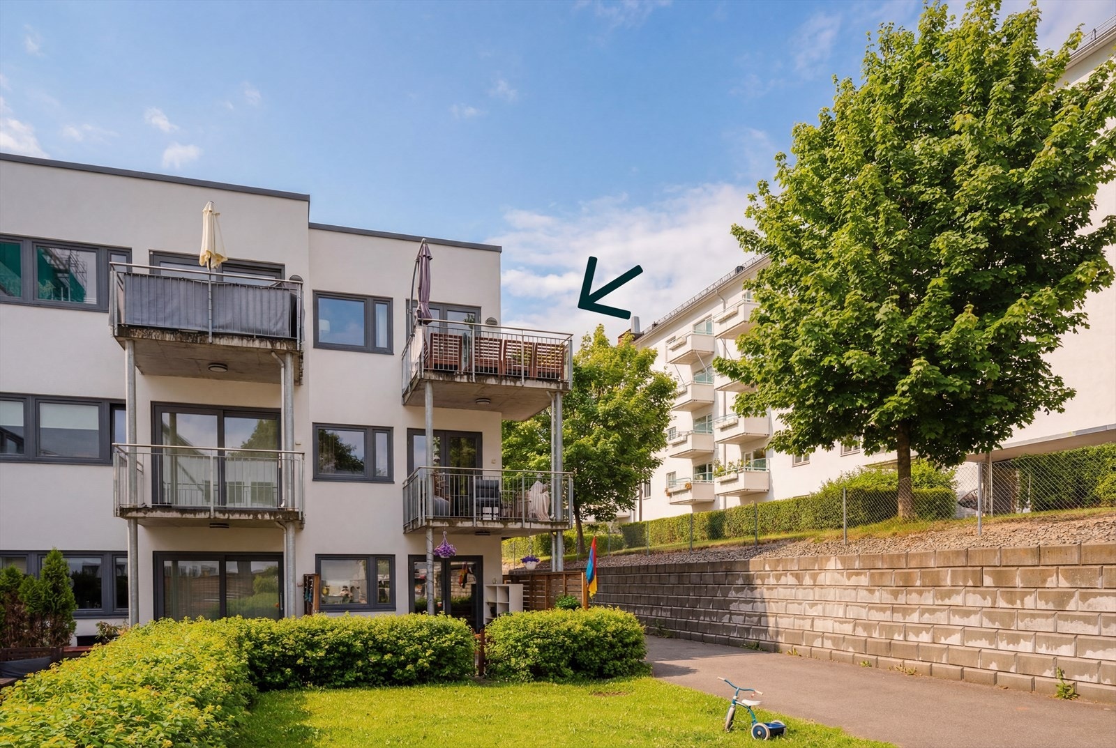 Om sommeren ser det slik ut. Det er gressplen foran og bak bygningen, samt store og grønne trær mellom bygningene. Galleribilde