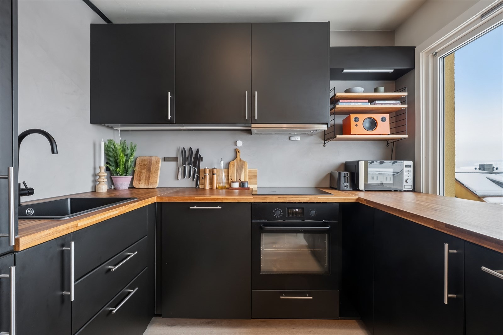 Kjøkken innredningen har glatte fronter, laminerte skrog og en laminert benkeplate med nedfelt kjøkkenkum. Galleribilde