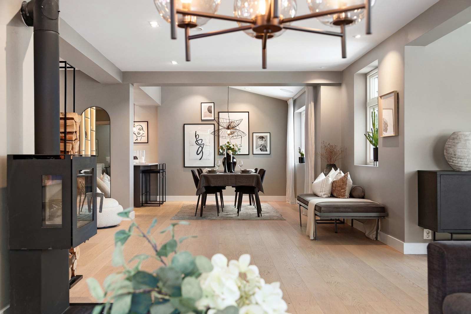 Spisestue i naturlig tilknytning til kjøkkenet, sittegruppe ved utgangen til hagen og en fin sofaavdeling ved peisovnen Galleribilde