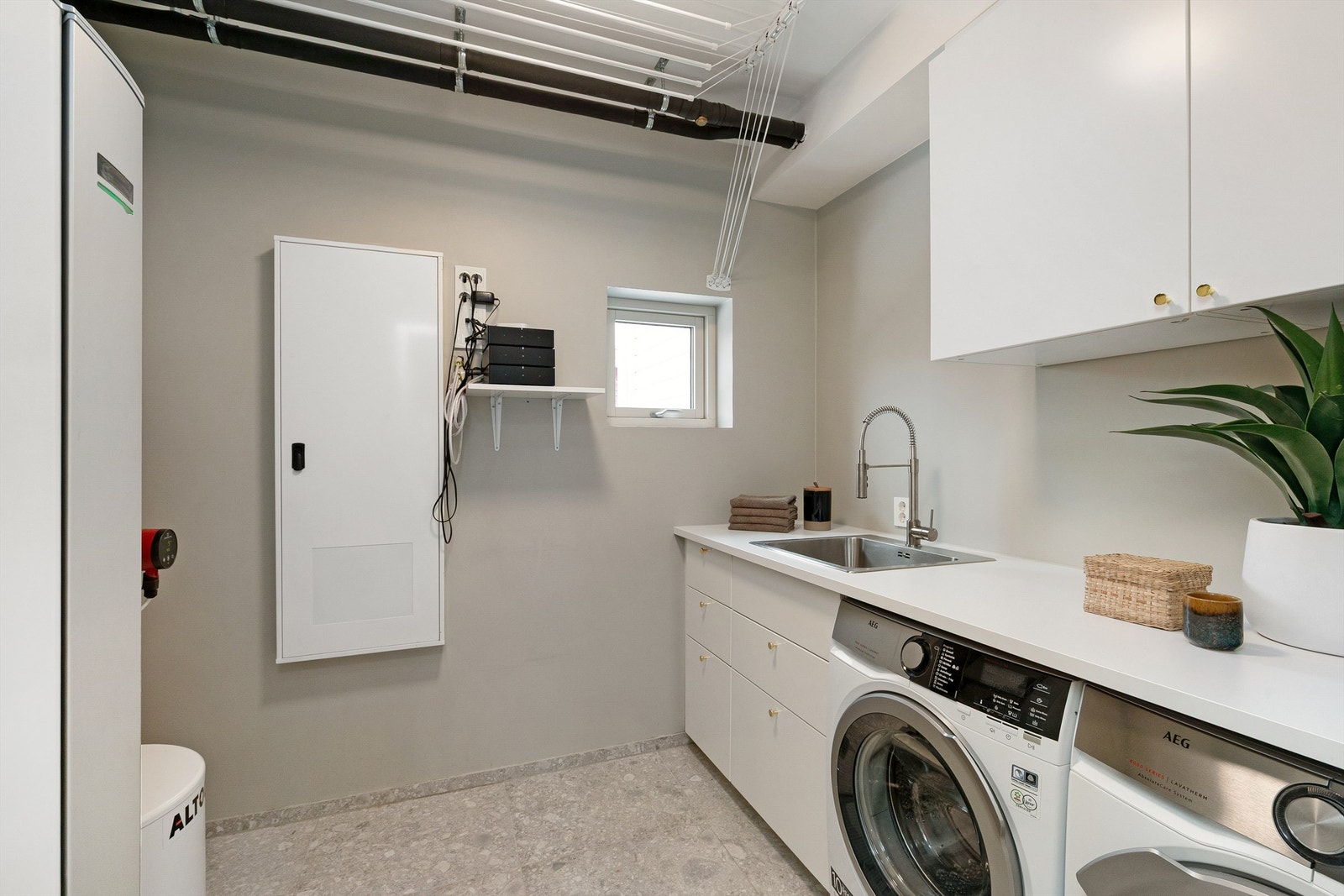 Innenfor badet er et et godt utstyrt vaskerom med opplegg vask/tørk side om side. Her er også tekniske installasjoner som varmtvannsbereder og anlegg for vannbåren varme Galleribilde