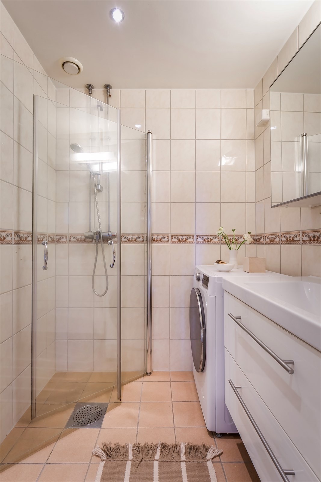 Badet har dusjnisje med innfellbare dusjvegger, dimbare downlights i taket og vegghengt toalett. Galleribilde