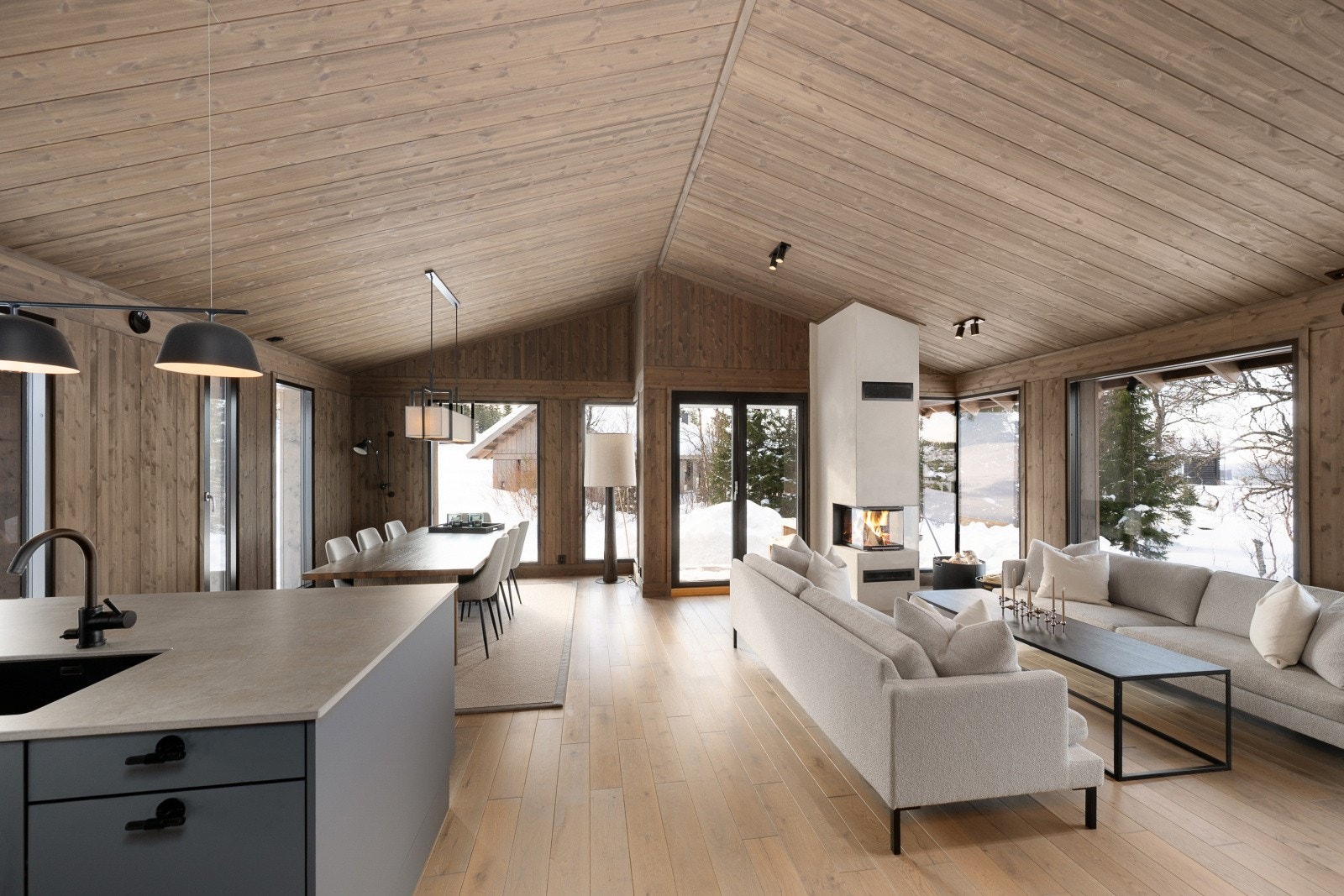 Den åpne stue- og kjøkkenløsningen er hyttas sosiale sone, med god takhøyde og store vindusflater. Galleribilde
