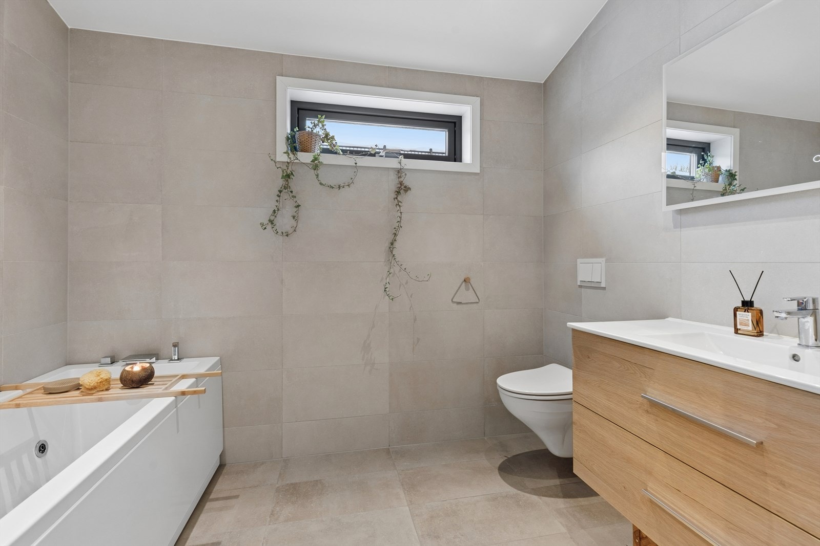 Delikat og romslig bad med store fliser på gulv og vegger som gir et moderne og tidløst uttrykk. Badekar er et "must" for barnefamilier, og med boblebadekar er det enda morsommere. Galleribilde