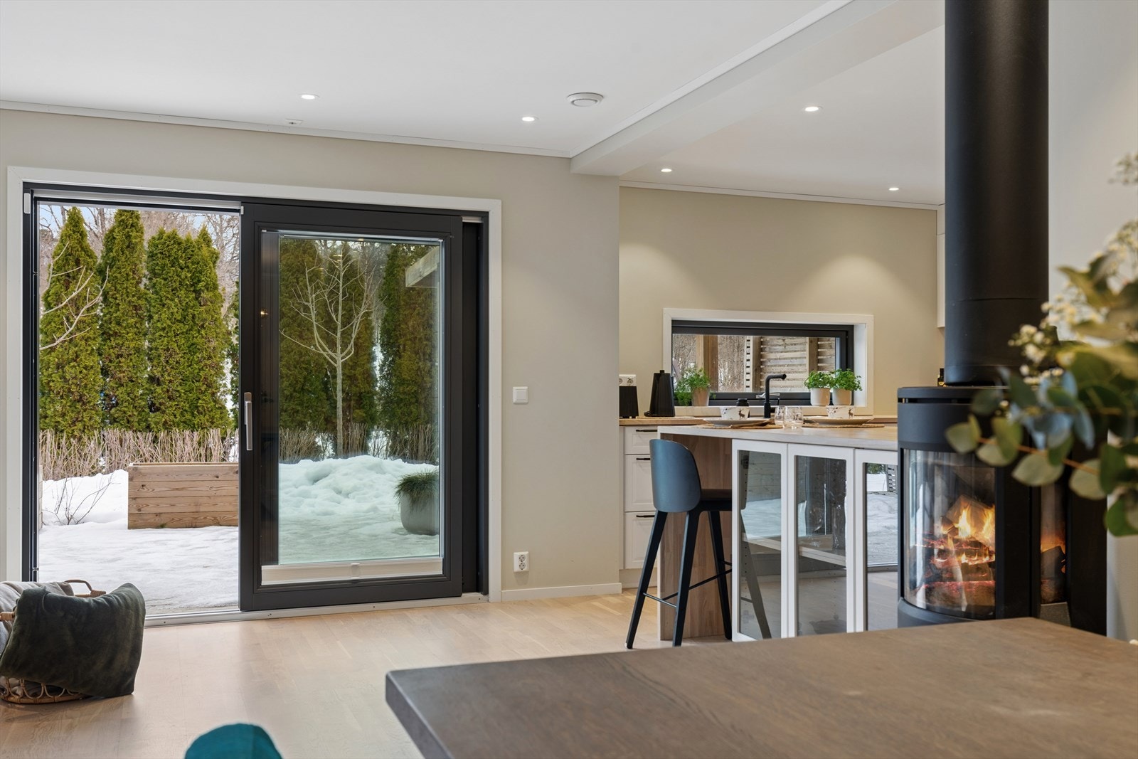 Stue og kjøkken i åpen løsning med skyvedører som fører ut til usjenert terrasse . Galleribilde