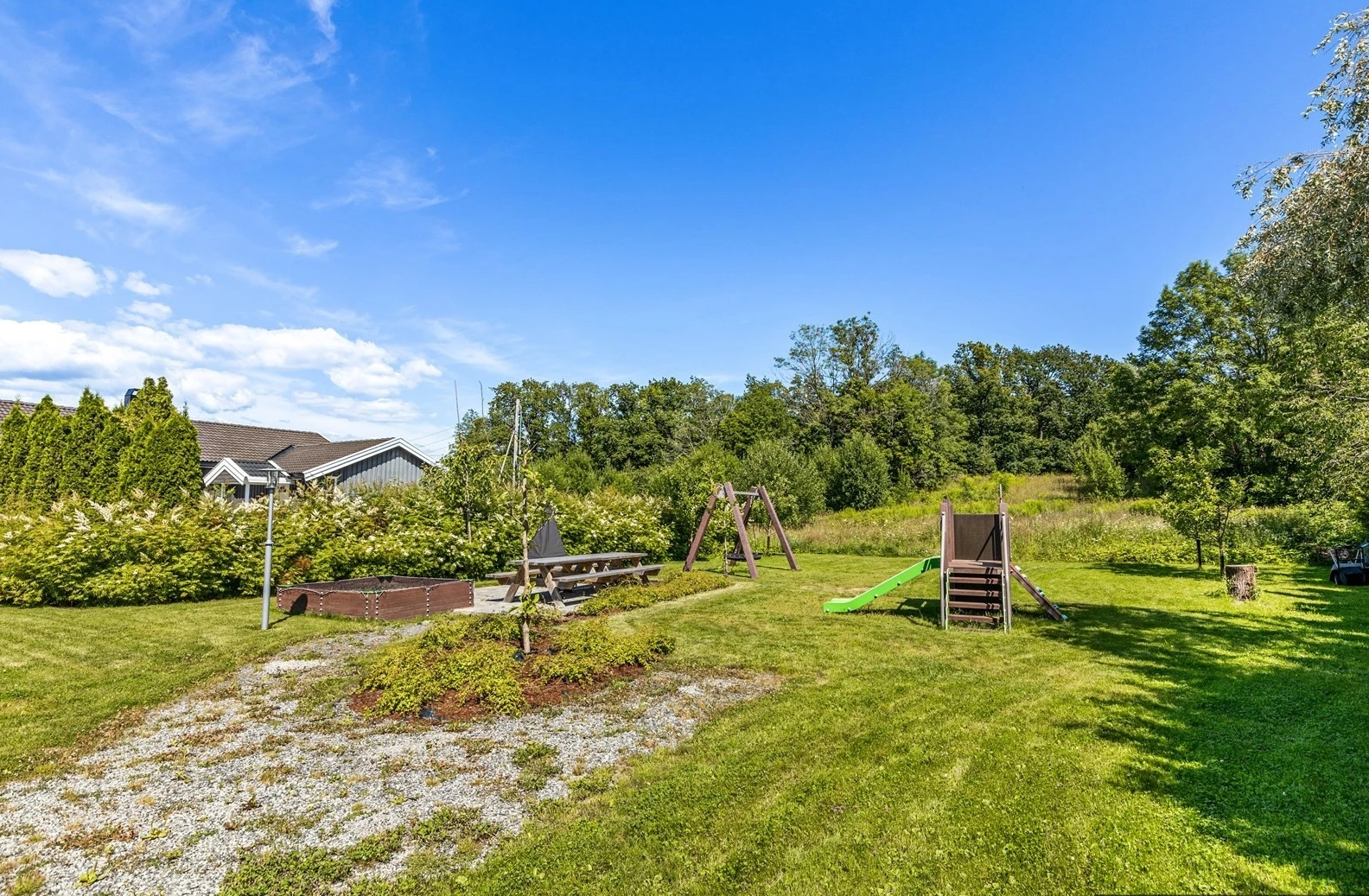 Sommerbilde fra fellesområdet som er tilrettelagt for liten og stor. Galleribilde