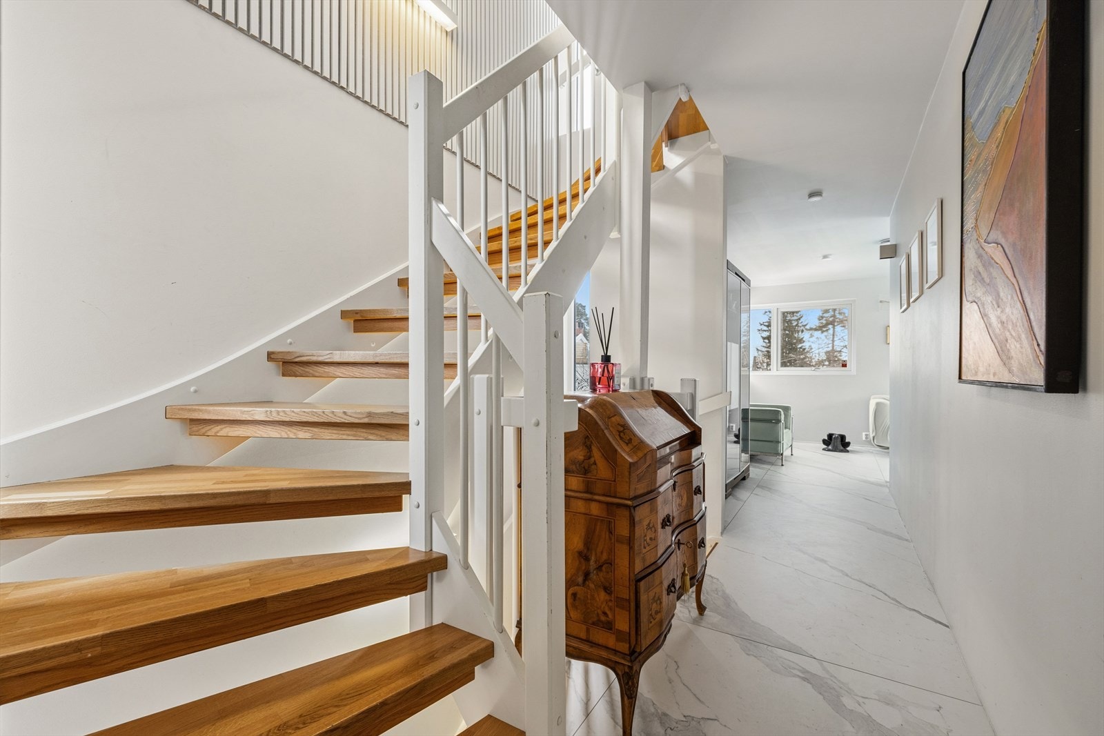 Boligen har en innvendig tretrapp med 180 graders sving mellom underetasjen og 2. etasje. Trappen er hvitmalt med beisede trinn og hvitmalt rekkverk med stående spiler. Galleribilde