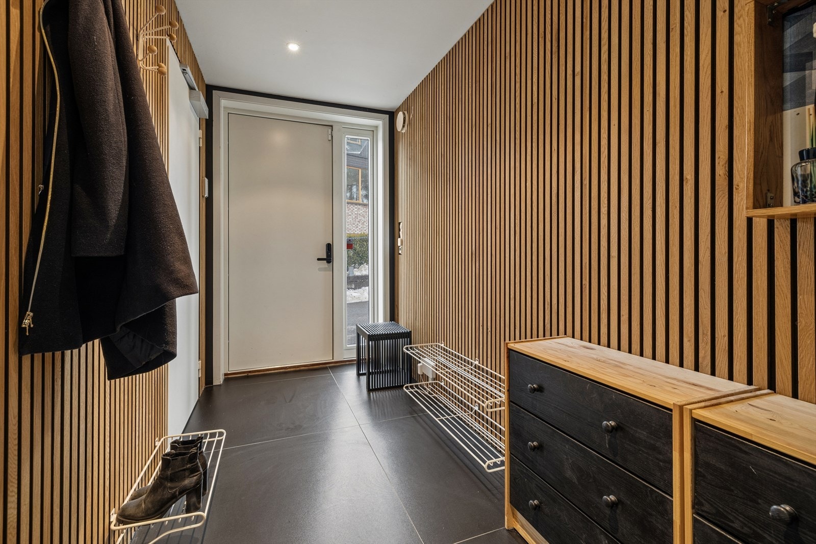 Velkommen inn i en romslig og praktisk entré. Adkomst til boligen enten via ytterdør eller fra garasje. Galleribilde