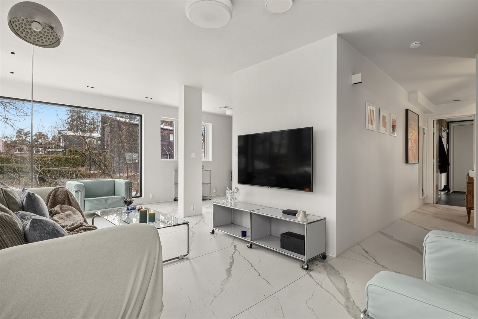 Boligen er smakfullt gjennomført med store vindusflater, lyse fargevalg og lekre gres porcellenato-påkostete fliser på gulv Galleribilde