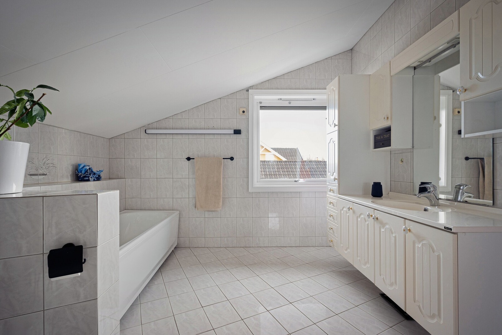 Badet i loftsetasjen er romslig og inneholder badekar, dusjløsning, toalett og servantinnredning. Galleribilde