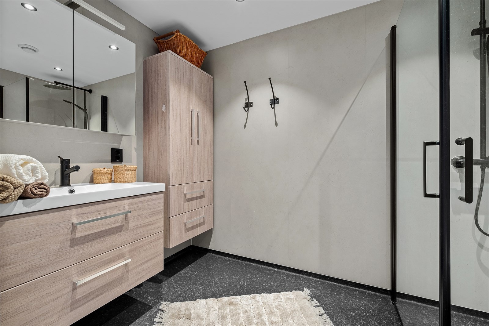 Flott bad utstyrt med innfellbare dusjdører, servantskap og mekanisk avtrekk Galleribilde