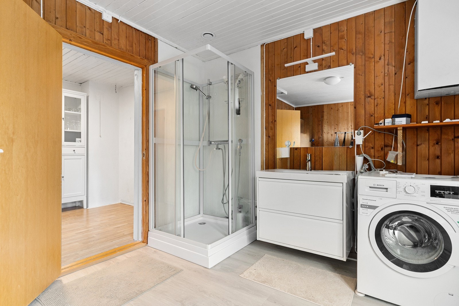 Bad i utleiedelen. Innredet med servant i baderomsinnredning, dusjkabinett og opplegg for vaskemaskin. Rommet er ikke bygget som et våtrom. Galleribilde