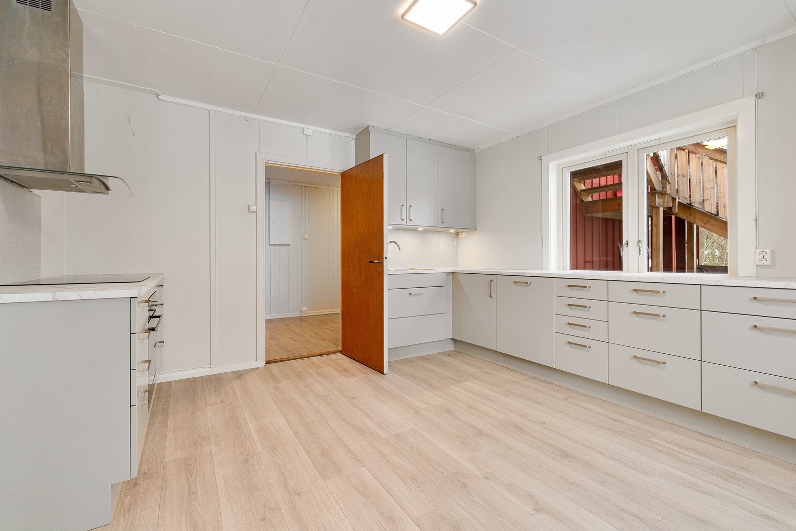 Kjøkkeninnredningen har lysegrå, glatte fronter og laminert benkeplate. Galleribilde