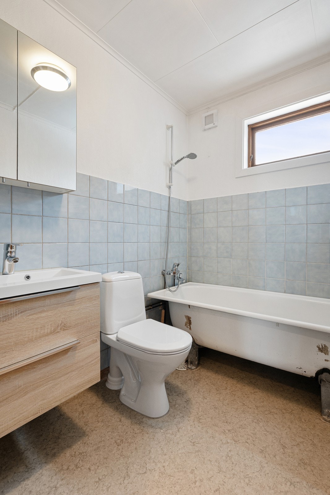 Badet er innredet med servant i baderomsinnredning, speilskap, toalett og badekar. Galleribilde