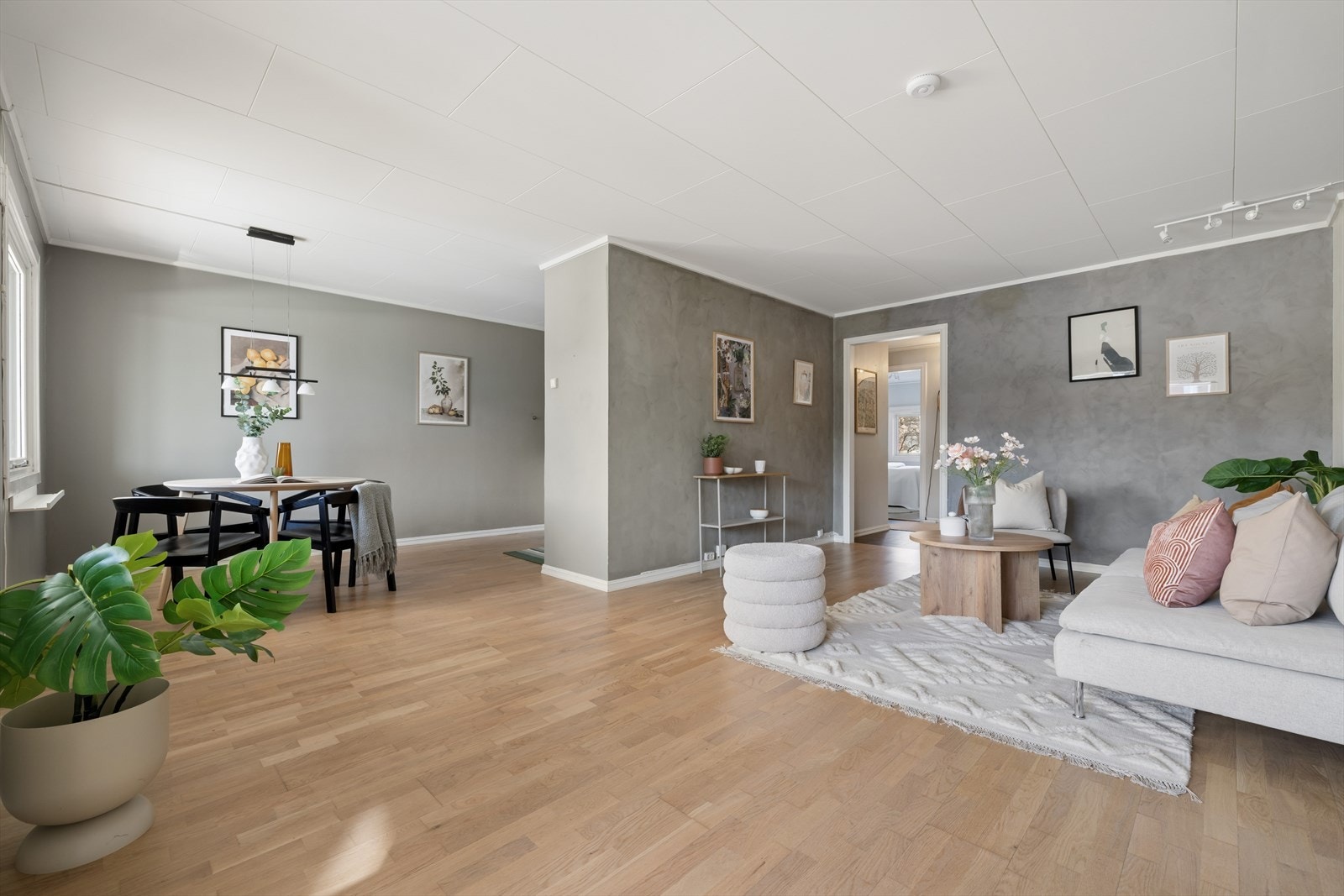 Lys og moderne stue med åpen løsning mot kjøkken med spiseplass. Et sosialt samlingspunkt med god flyt og romfølelse. Galleribilde