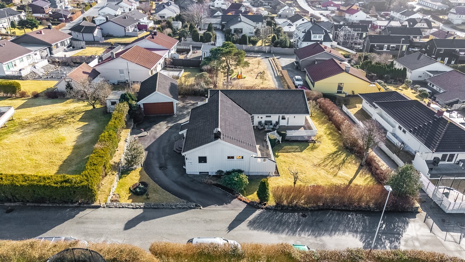 Tomten er pent opparbeidet med et stort asfaltert gårdsrom som gir rikelig med parkeringsplass og enkel adkomst. Galleribilde