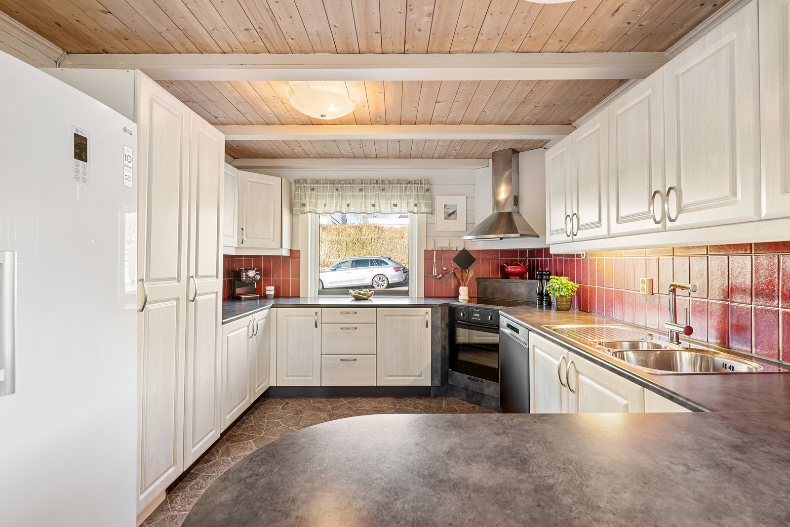 Kjøkkenet er romslig og praktisk utformet med god skap- og benkeplass samt egen spisekrok. Galleribilde