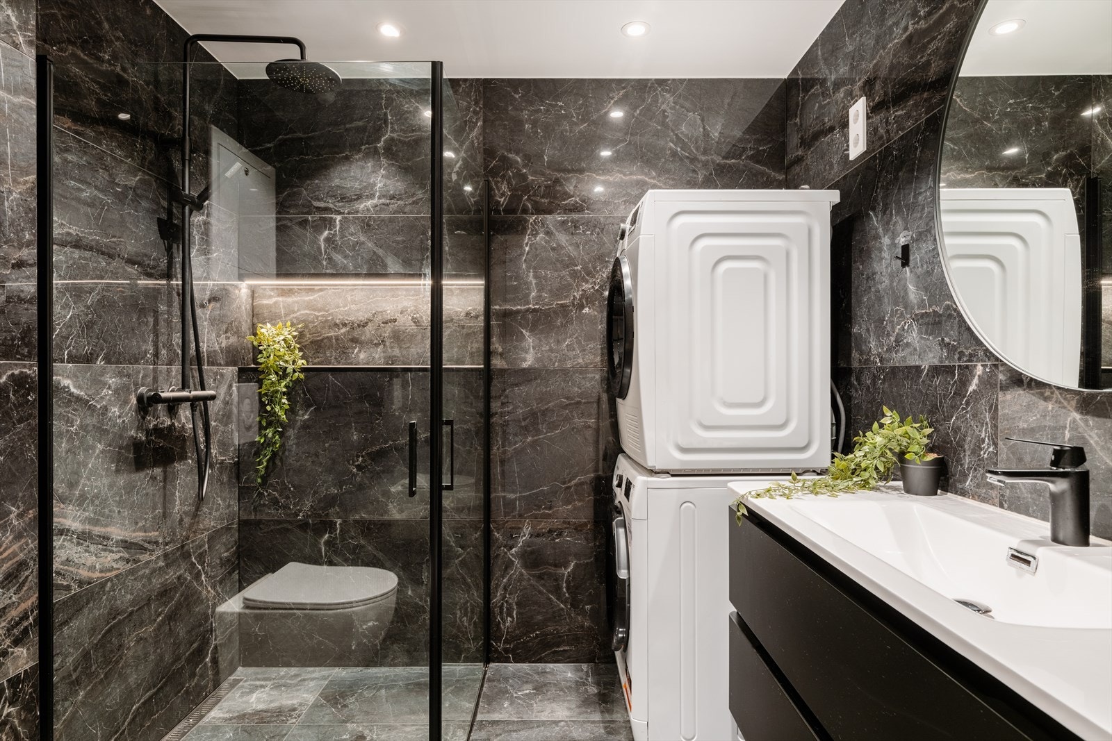 Her er det dusjhjørne med innfellbare glassdører, veggmontert toalett og mekanisk avtrekk. Galleribilde