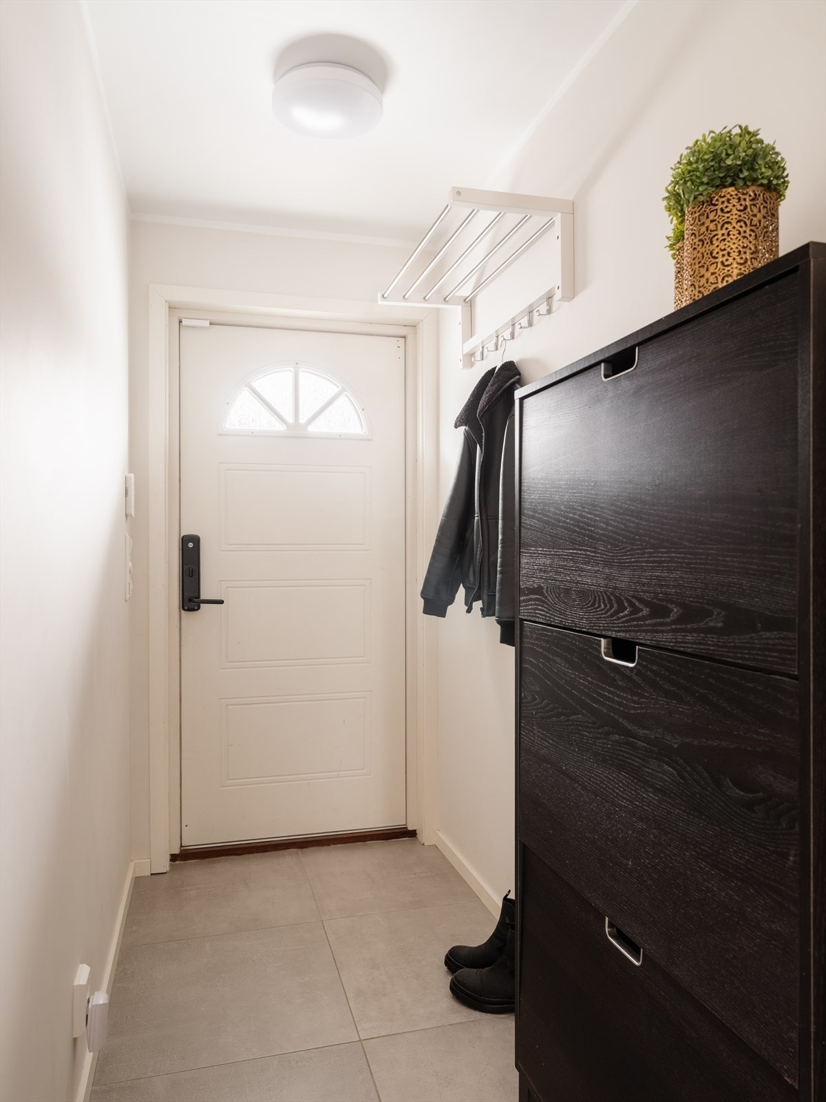 Velkommen inn i en lys entré med flislagt gulv og plass til yttertøy. Galleribilde