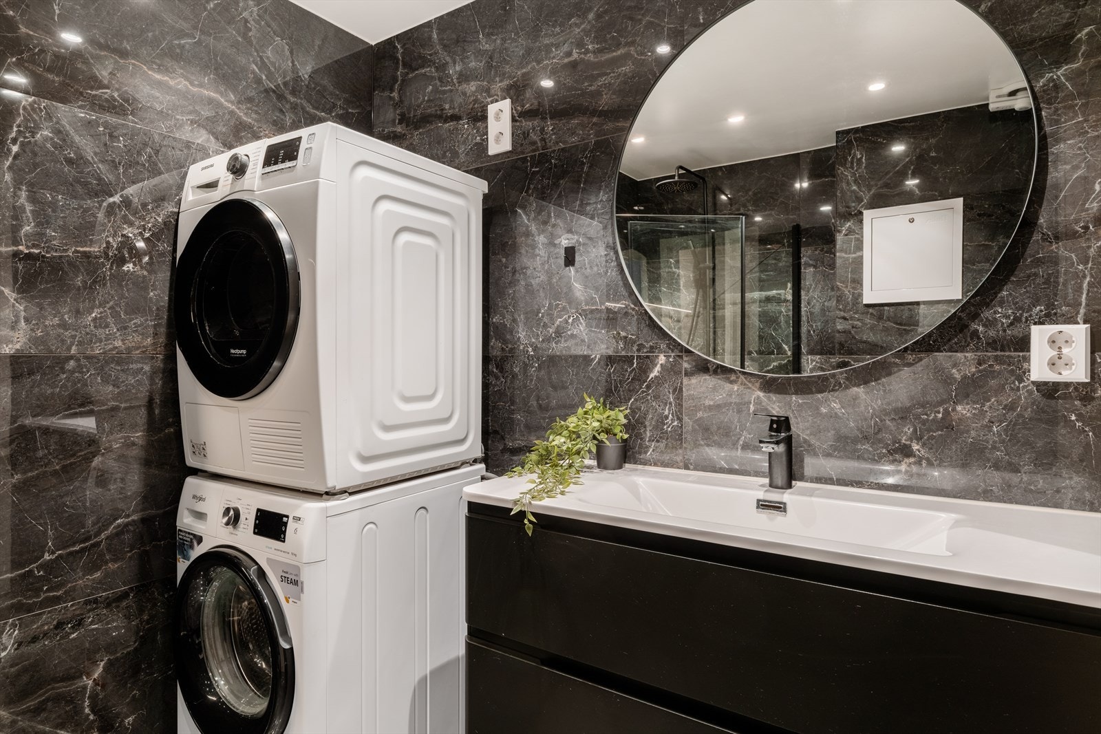 Badet har en stilren innredning med servant og praktisk opplegg for vaskemaskin. Galleribilde