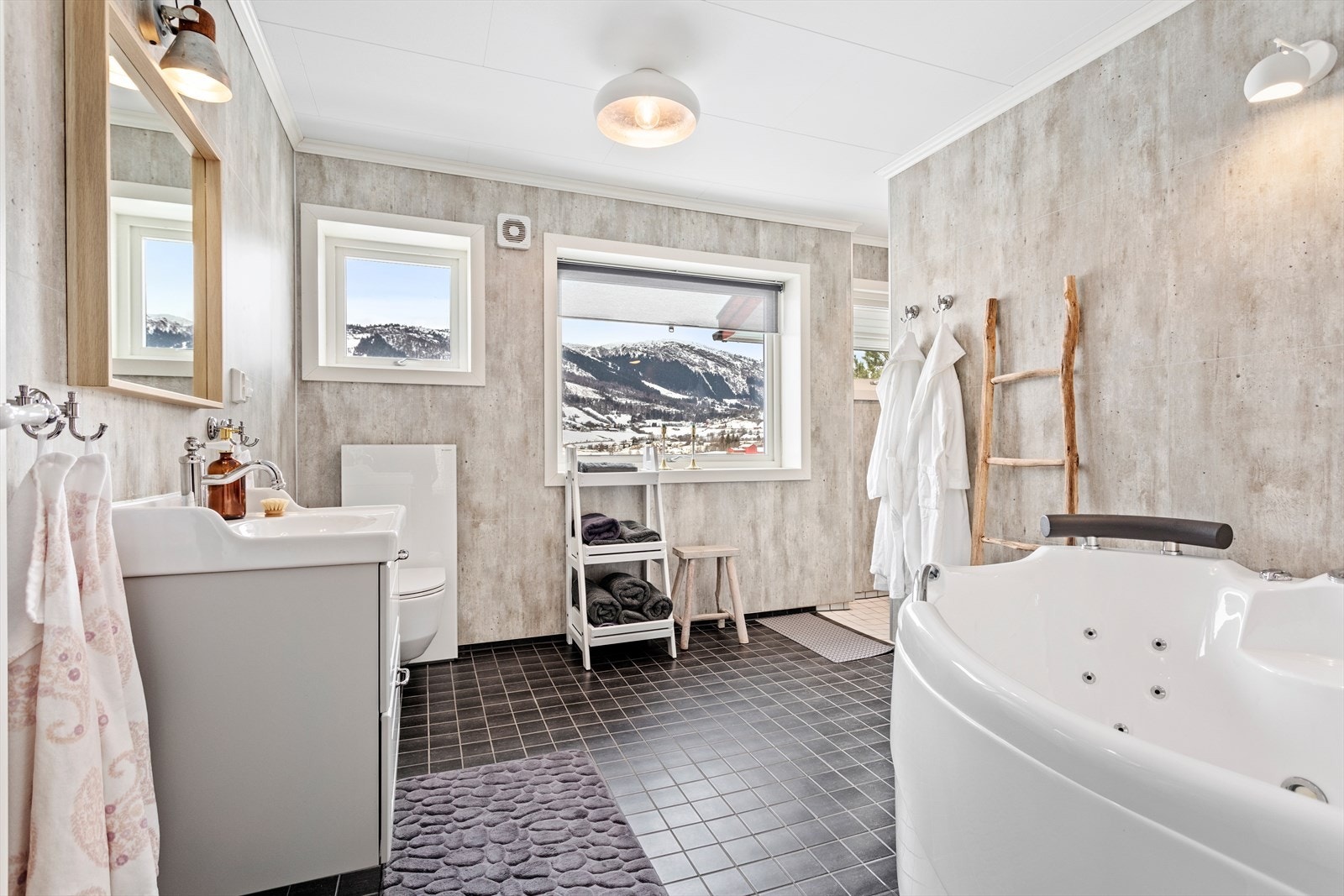 Innreiing består av hjørneboblebadekar, vegghengt toalett, nedfelt servant med underskuffer, dusjnise. Galleribilde