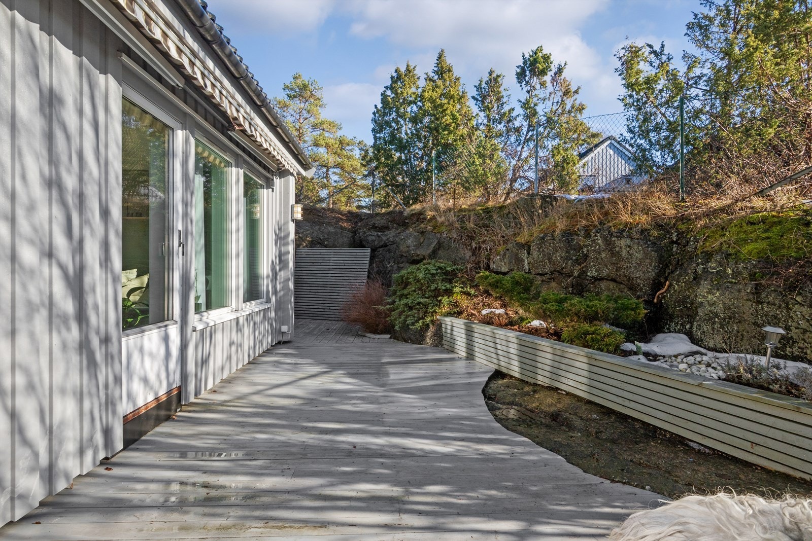 Tomten er opparbeidet med plen, noe beplantninger som skjermer uteplassene. Galleribilde