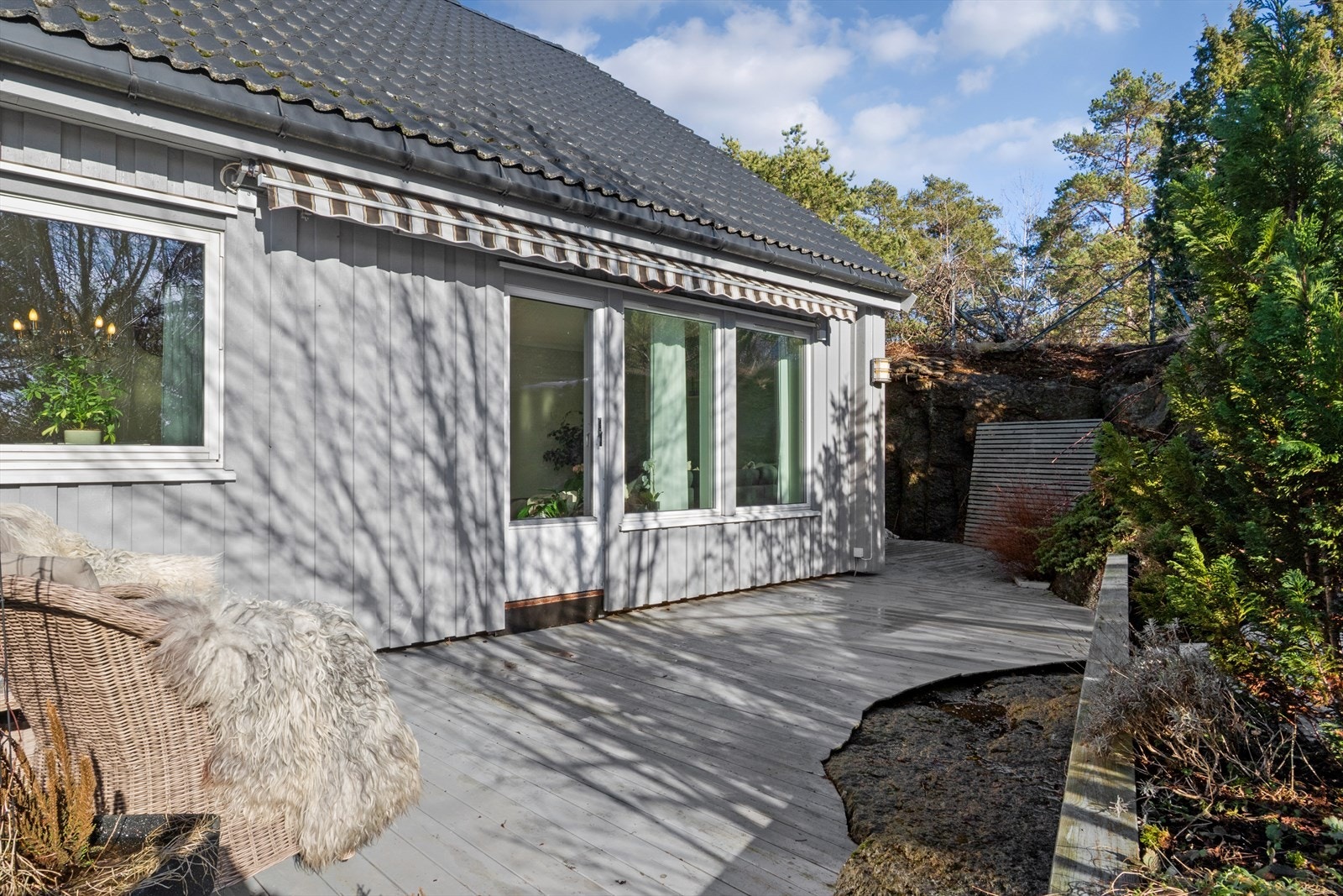 Fra stuen er det direkte utgang til en skjermet terrasse, som strekker seg rundt hele boligen. Galleribilde