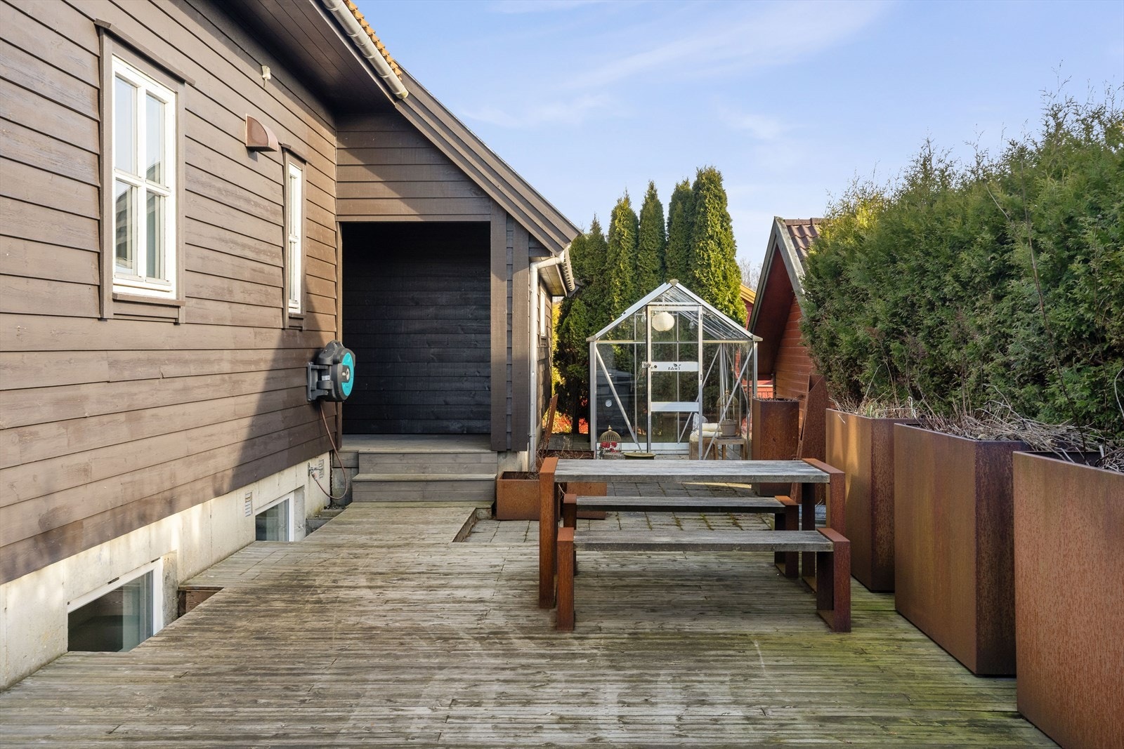 Terrassen som strekker seg rundt på to sider av boligen. Plantekassene medfølger i handelen. Galleribilde