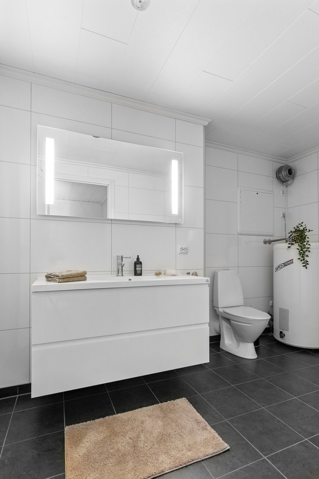 Tidløs hvit skuffe innredning og speil med innfelt lys. Galleribilde