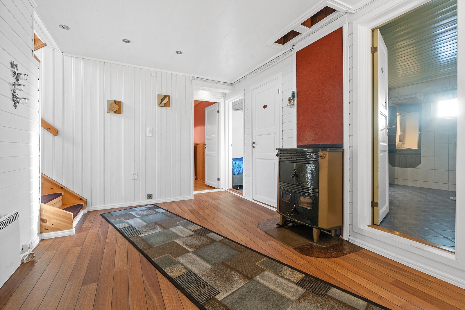 Hallen i underetasjen binder rommene sammen. Den lakkerte tretrappen er fra 2007. Galleribilde