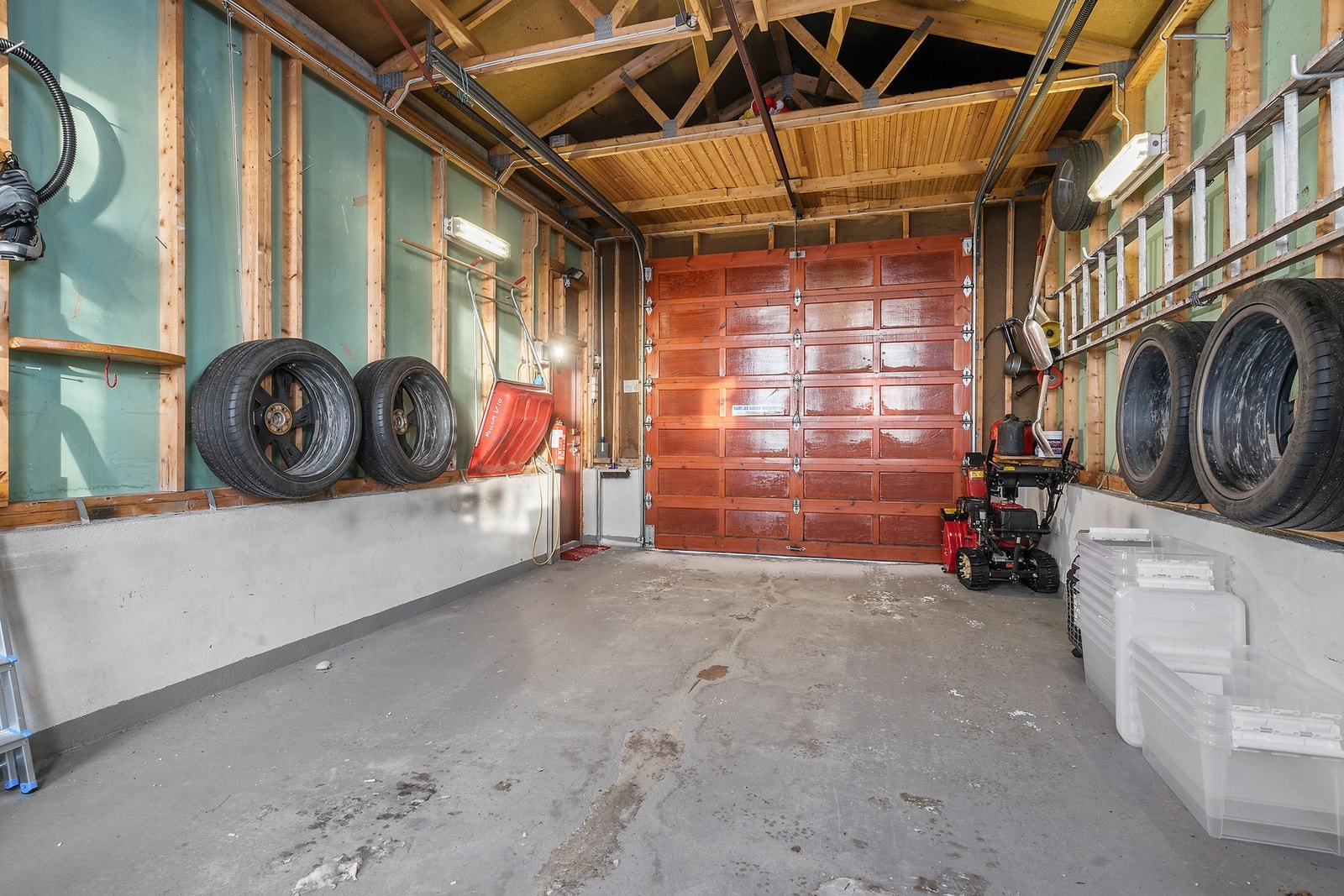 Garasjen har en leddet furuport med portåpner for enkel adkomst. Galleribilde