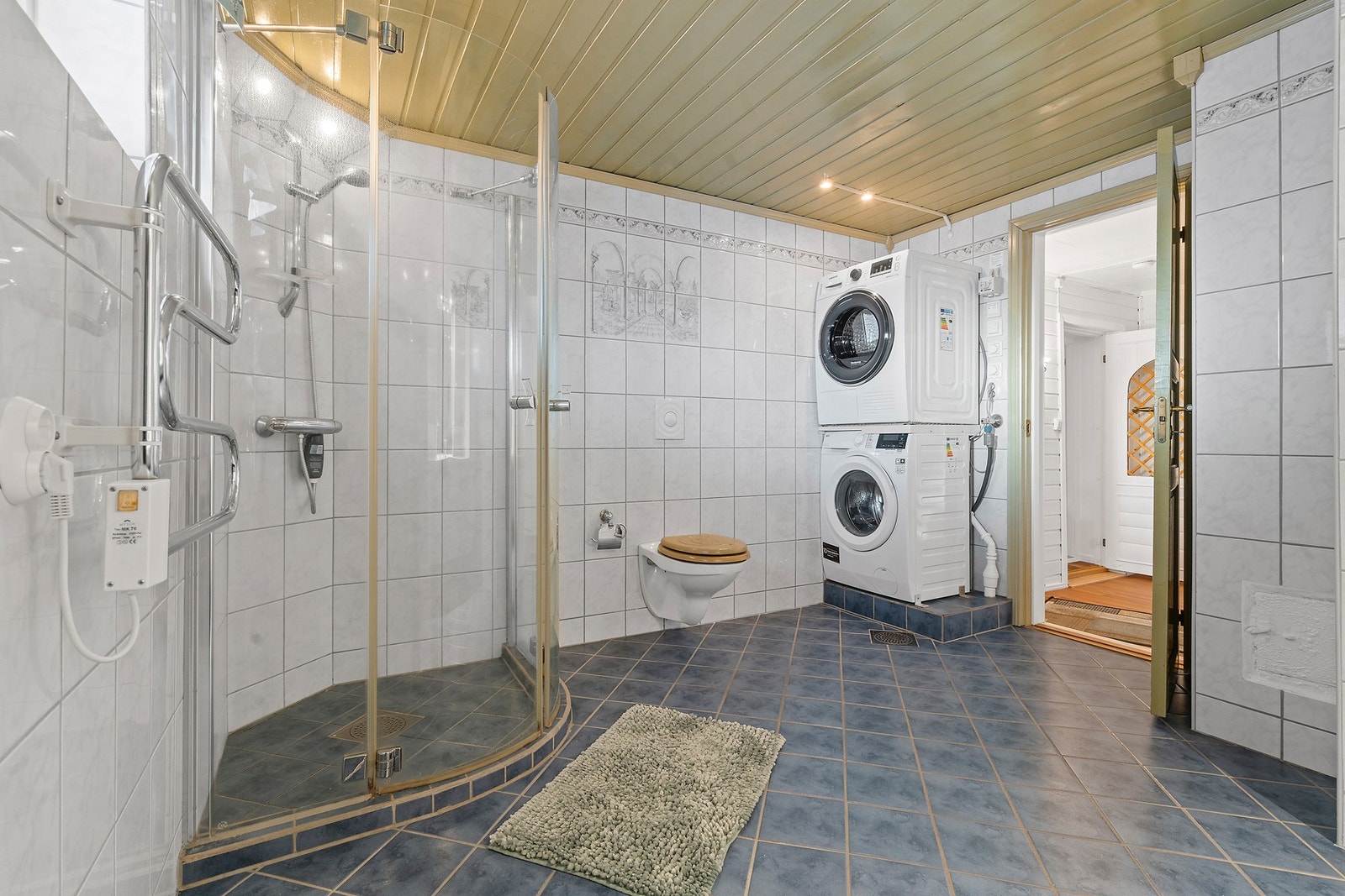 Rommet er utstyrt med dusjhjørne, veggmontert toalett og har opplegg for vaskemaskin. Galleribilde