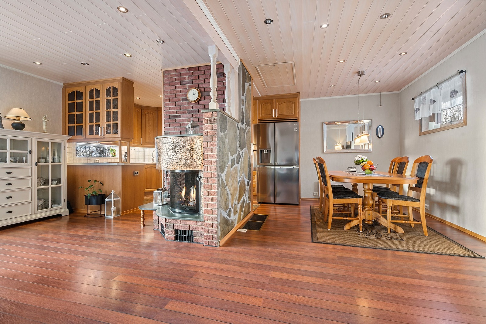 Det sosiale allrommet har en sentralt plassert mursteinspipe med peisinnsats som gir varme. Galleribilde