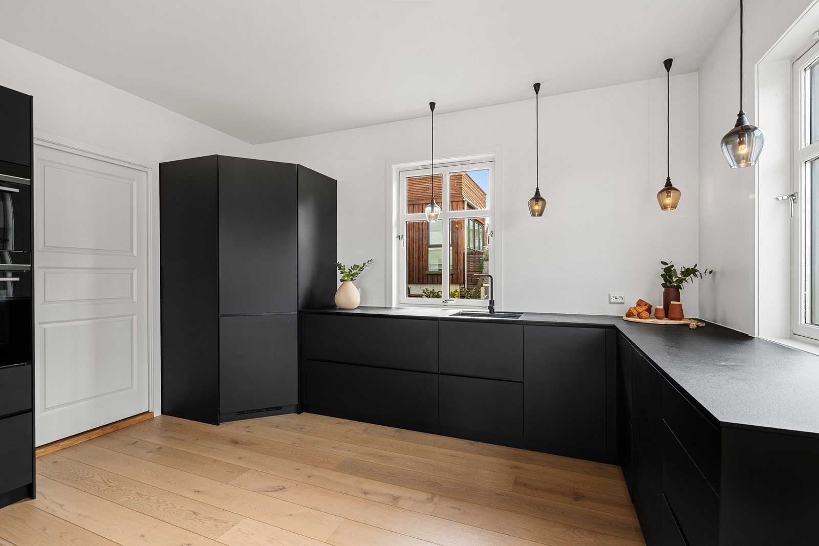 Kjøkkenet har et hjørne kjøleskap, med ekstra mye oppbevaringsplass Galleribilde