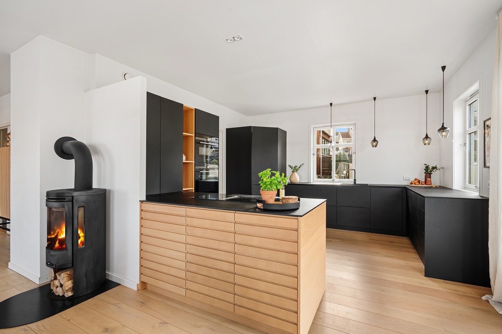 Kjøkken fra 2020 med en blanding av sorte og eik fronter med rikelig med skap og benkeplass. Galleribilde