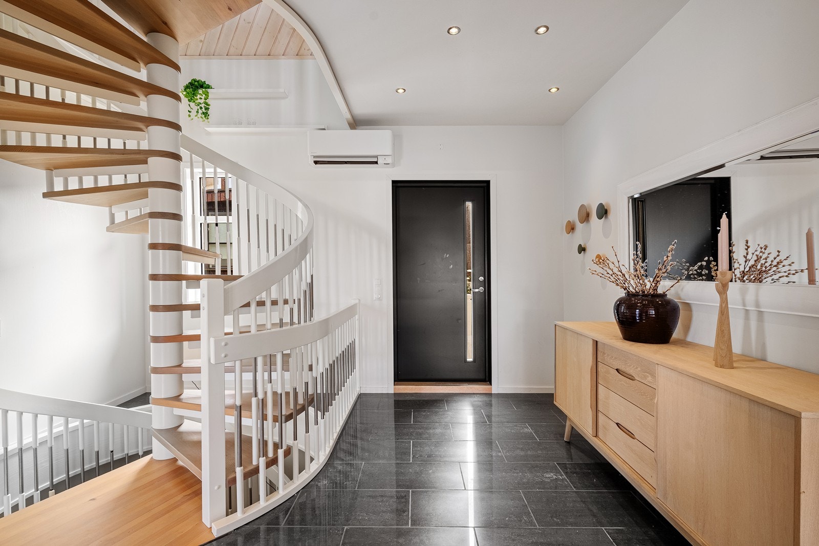 Entrè / trappegang med fliser på gulv, spotter i takt samt malte vegger. Her har man også en varmepumpe som bidrar til en komfortabel innetemperatur gjennom året. Galleribilde