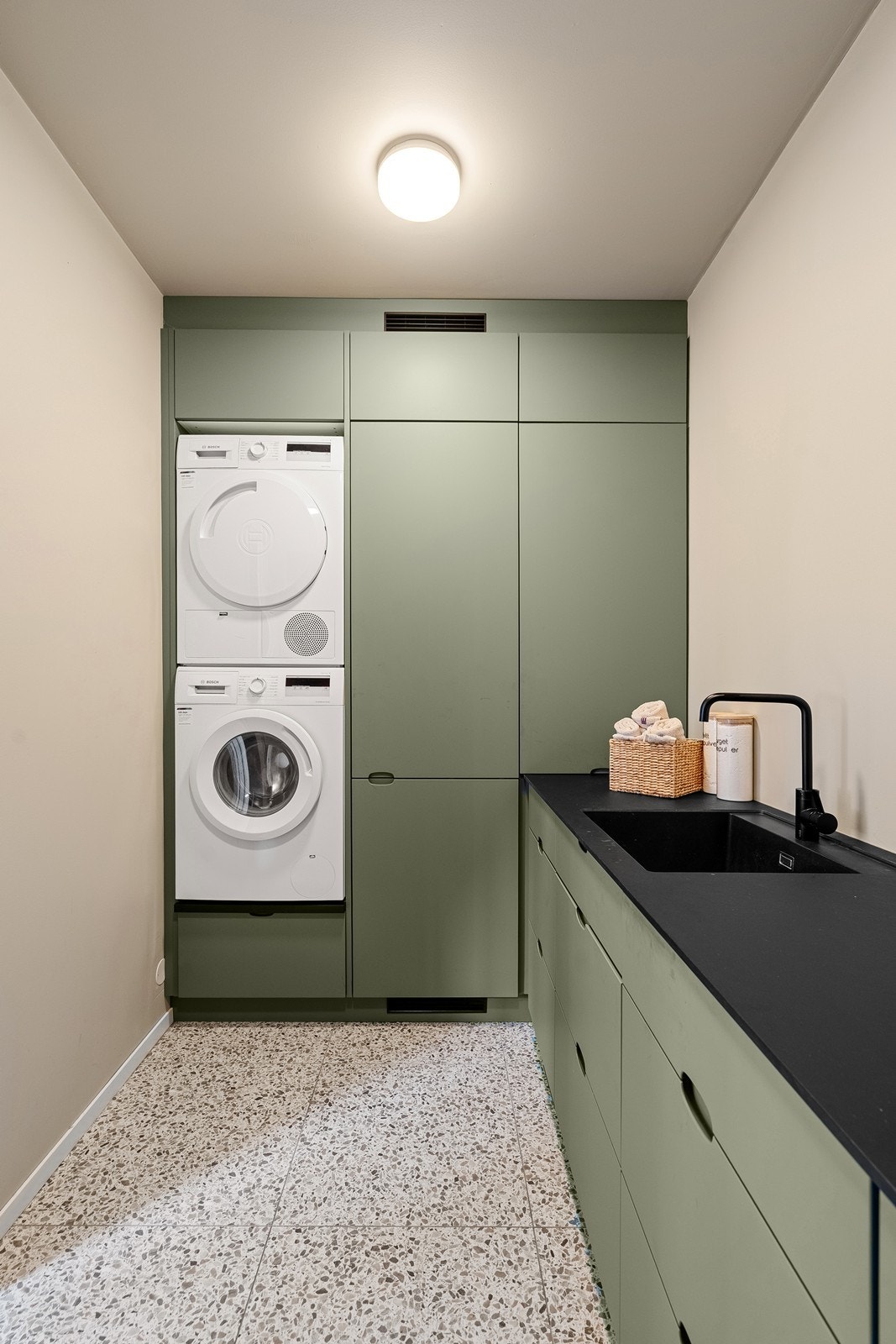 Vaskerommet har god skap og benkplass. Grønne fronter og sort benkeplate. Galleribilde