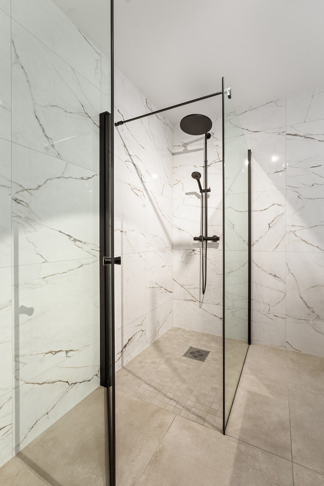 Flislagt dusjsone med elegante glassvegger og moderne detaljer. Galleribilde