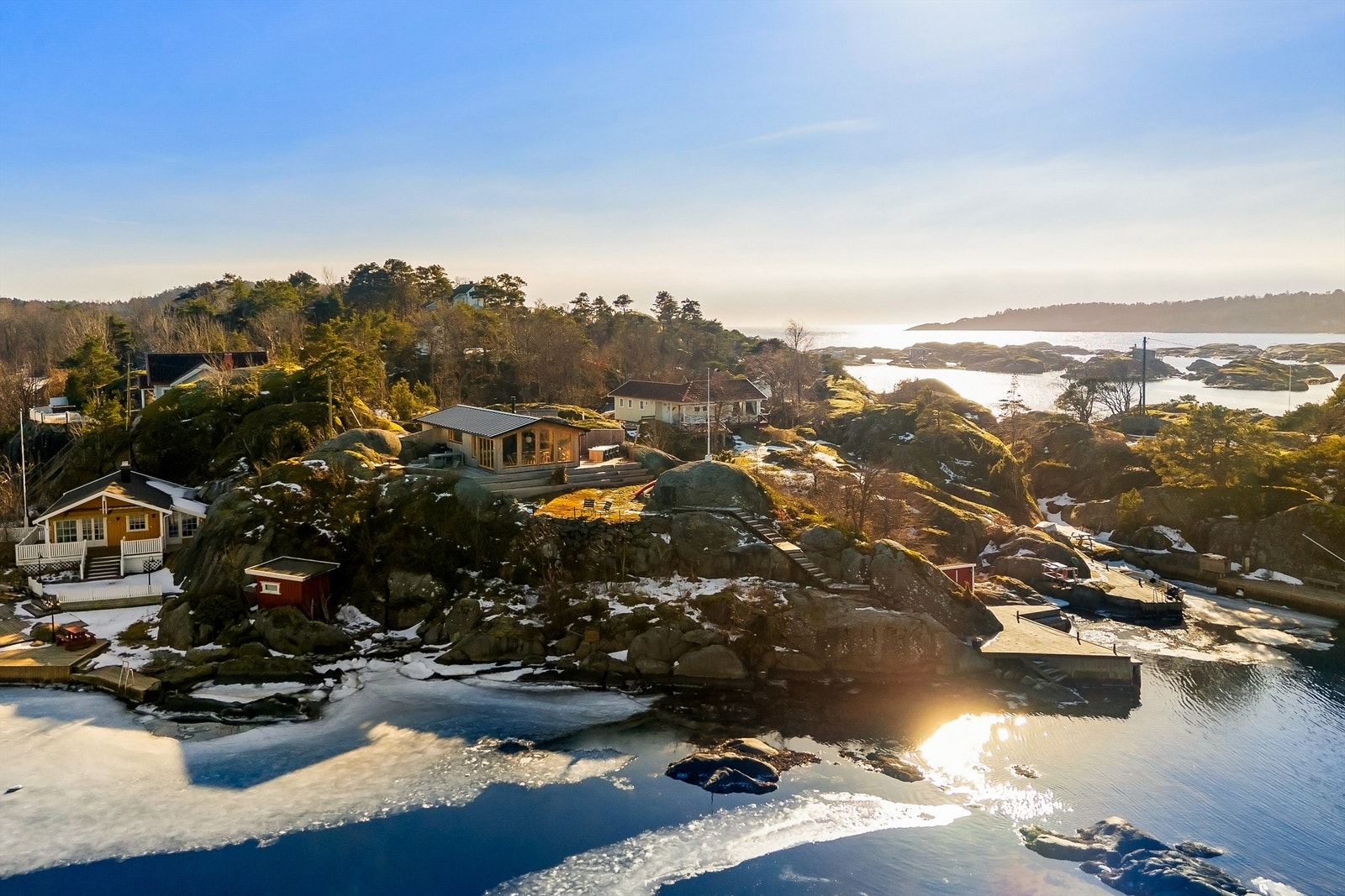 På Arøya ligger hyttene spredt i terrenget, byggestilen er varierende, de fleste med tradisjonelle smårutede vinduer. Også på denne tomten har det i sin tid stått en slik hytte, men den er for lengst revet og nå erstattet med denne moderne hytta. Galleribilde